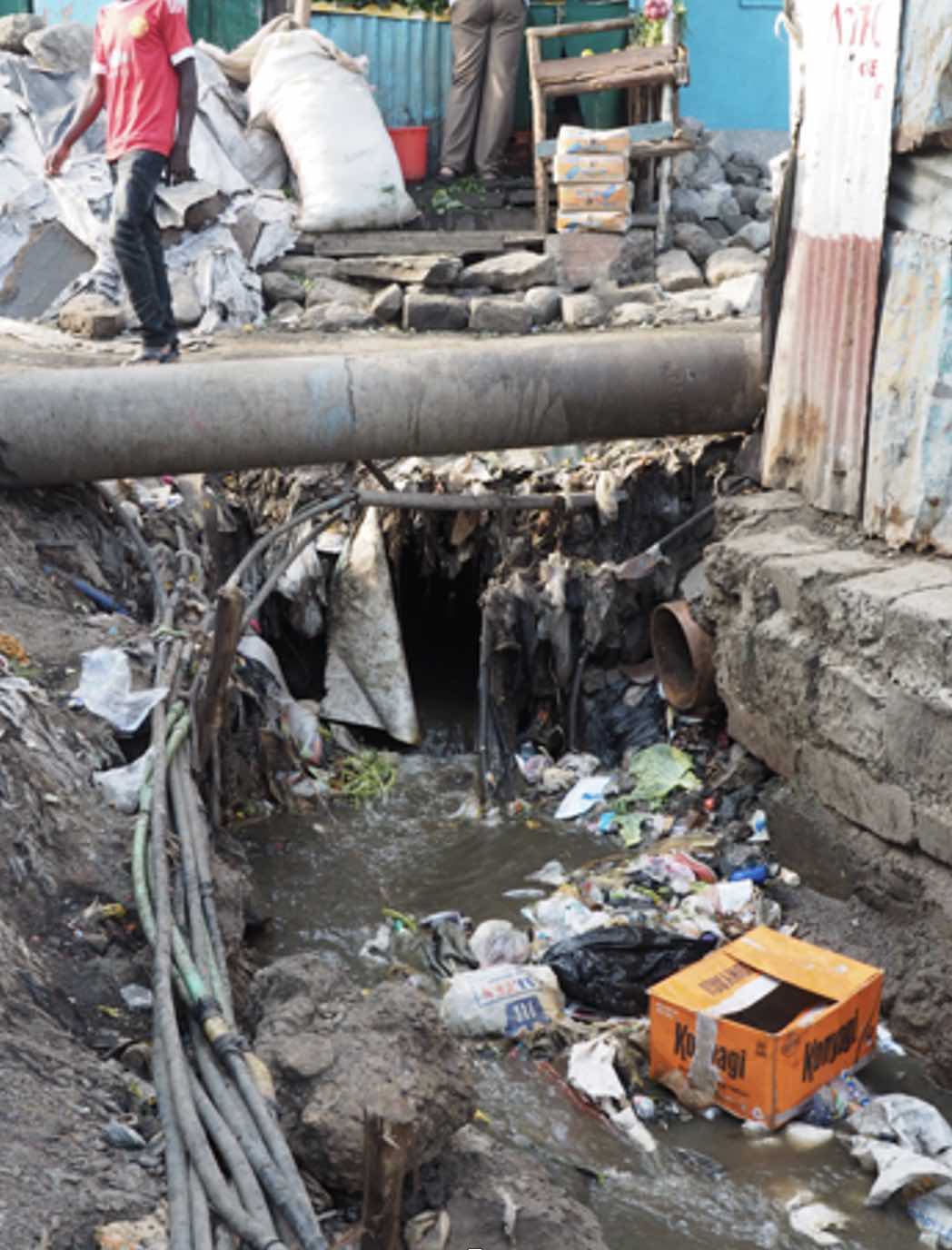 <b>Figure 1.</b> An open sewer and informal water pipes in Mukuru, Nairobi, Kenya.